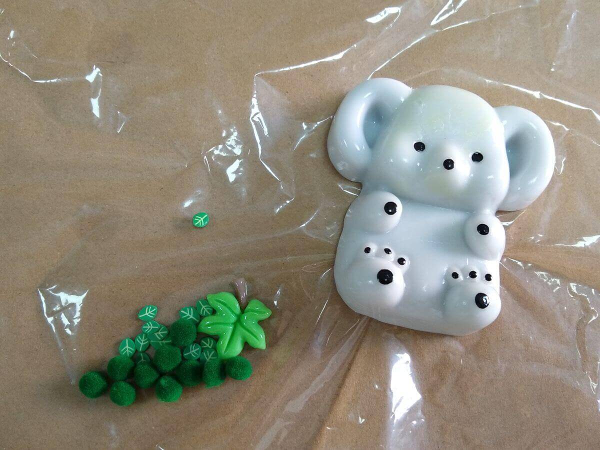 Squishy TPR koala separated from plastic leaf accessories for inspection