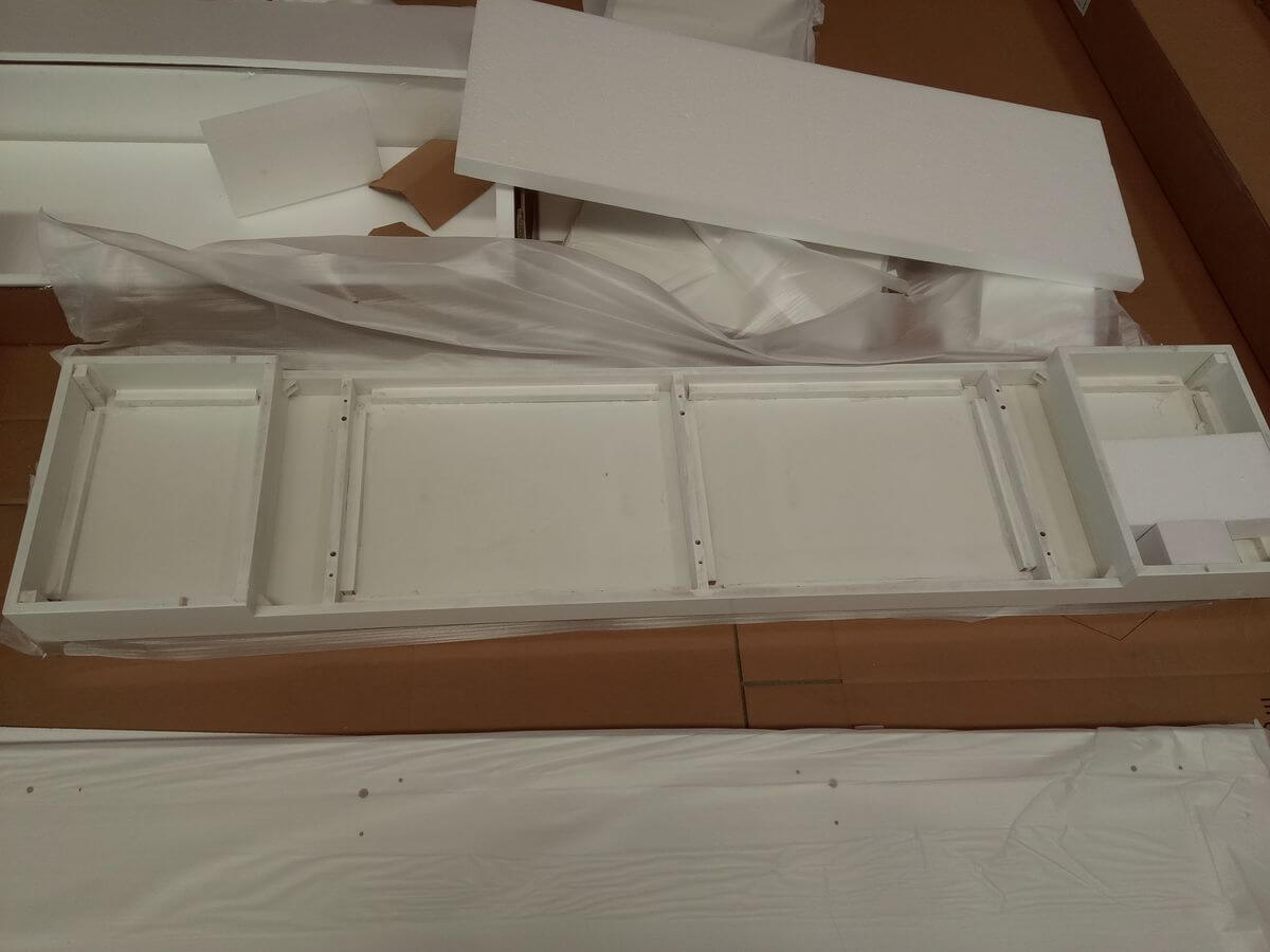 Another KD furniture carton showing panels with hardware mixed inside