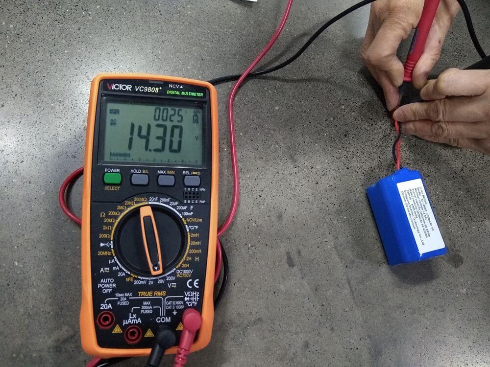 Voltage measurement — multimeter reading confirming battery voltage within spec