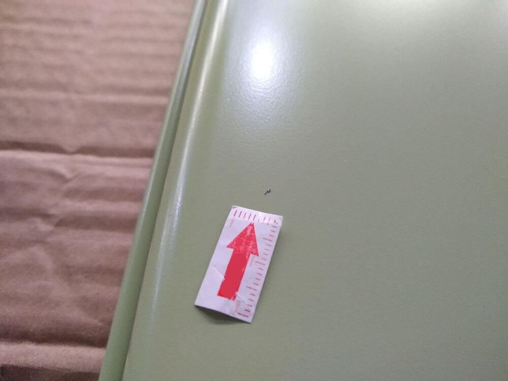 Dust contamination defect on oven tray — multiple specks embedded in painted surface