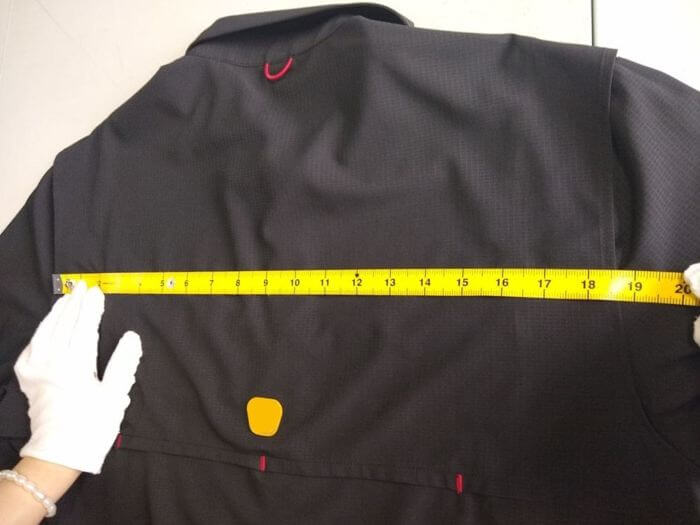 Apparel inspection in China: point-of-measure check on a sampled garment with tape