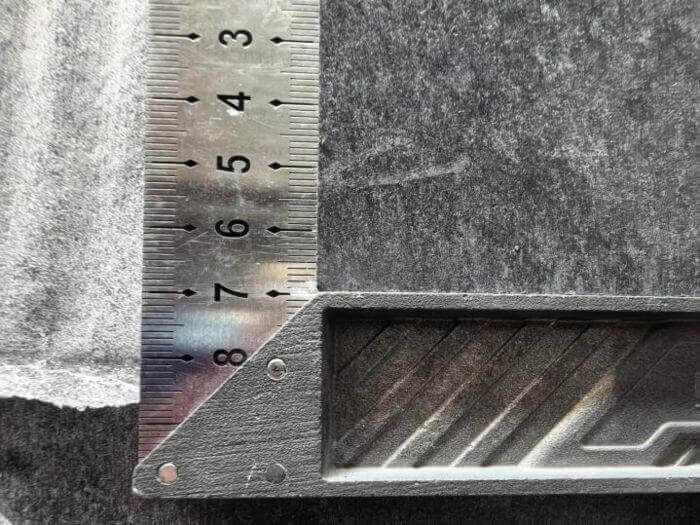 Building materials inspection in China: close-up of slab edge against straightedge blade