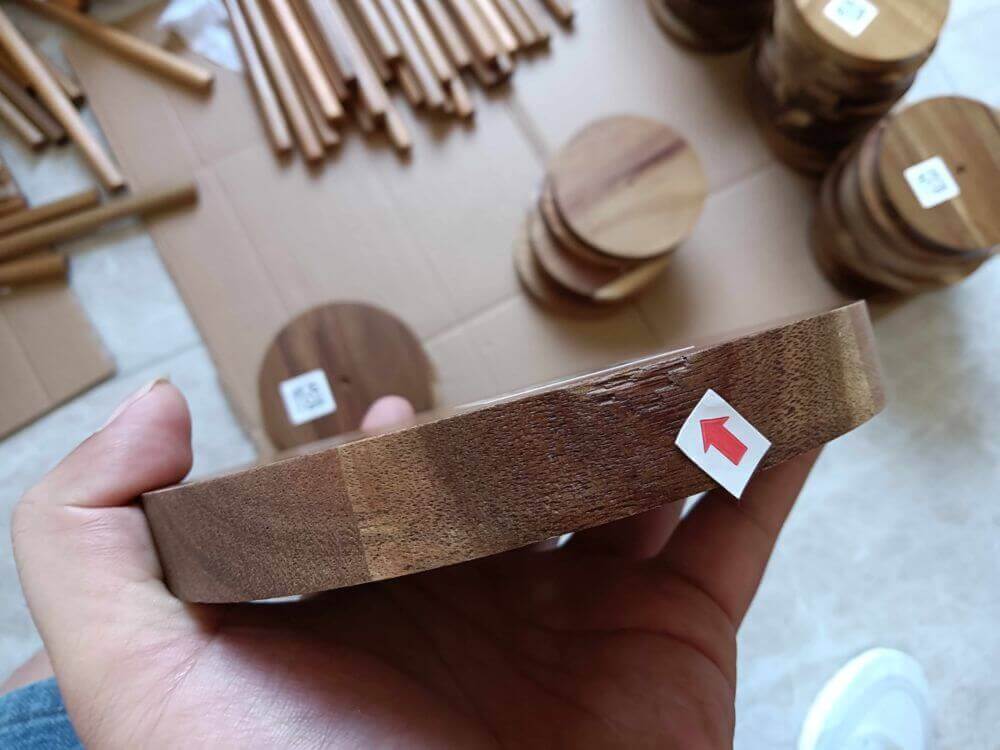 Edge chipping defect on acacia wood toilet paper holder base panel — found during pre-shipment inspection