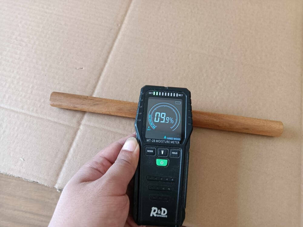 Moisture meter verification — acacia wood within 8%-12% ideal range, passed inspection